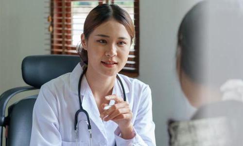 Mental health professional in a white coat talking to a patient